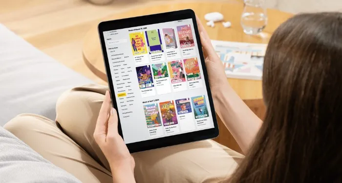 someone looking at the New Release Index romance books on a tablet