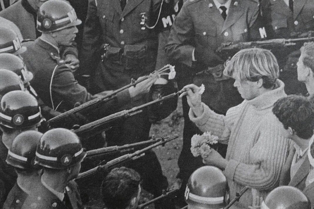 "Flower Power" was taken by Bernie Boston The Washington Evening Star on October 21, 1967, during the March on the Pentagon by the National Mobilization Committee to End the War in Vietnam. It shows a protester placing a carnation into the barrel of an M14 rifle held by a soldier of the 503rd Military Police Battalion (Airborne).
