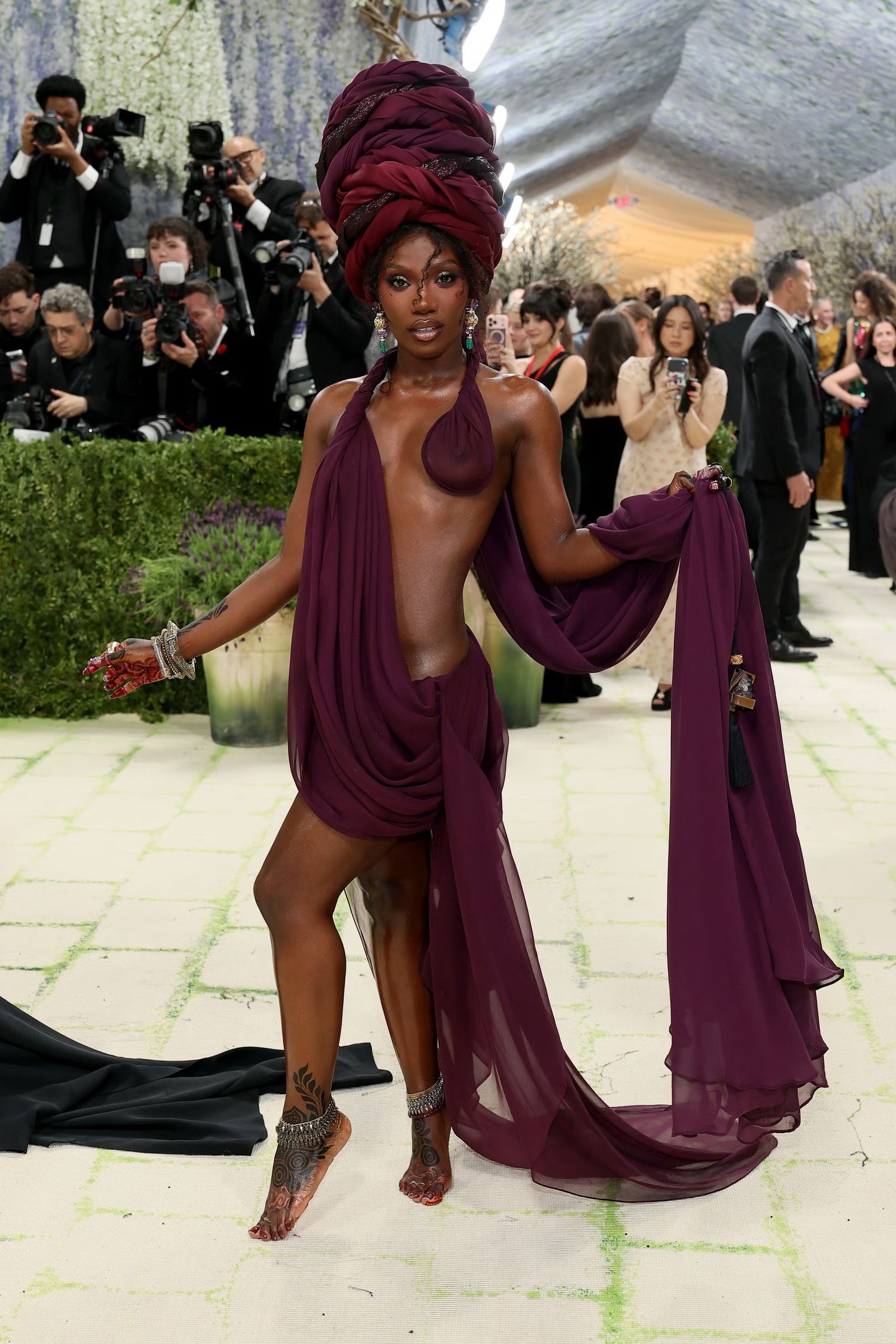 The rapper stole the show in a burgundy draped gown with cut-out detailing, worn with bare feet
