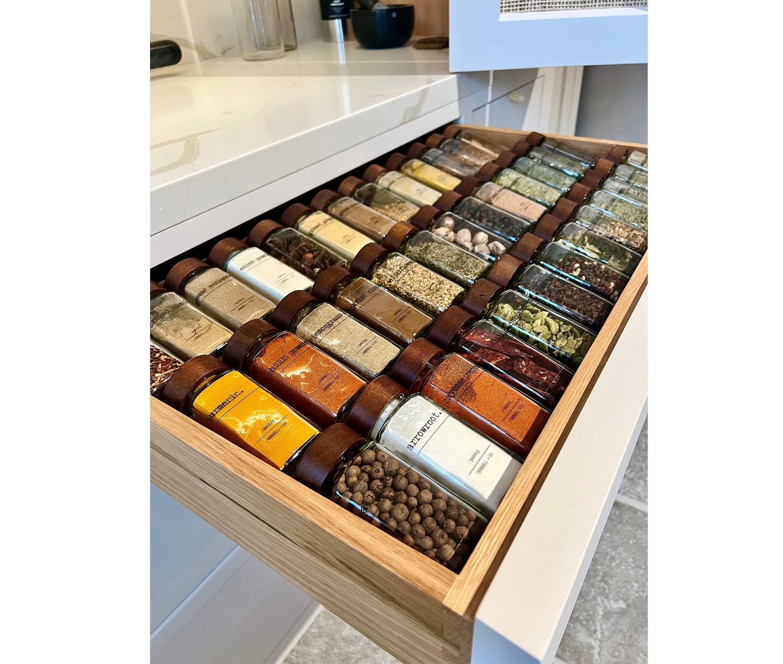 An angled spice drawer insert keeps ingredients organised, visible and easy to access in a warm contemporary kitchen (Studio Kendell + Co/PA)