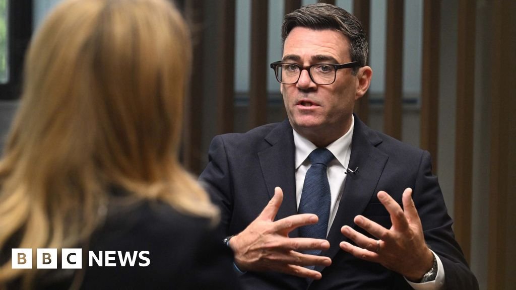 Burnham gestures as he speaks to the BBC's Laura Kuenssberg, who sits with the back of her head to camera.