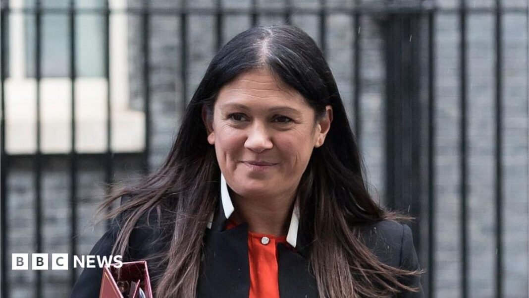 Culture Secretary Lisa Nandy smiling outside Downing Street. She has a black blazer and a red top.