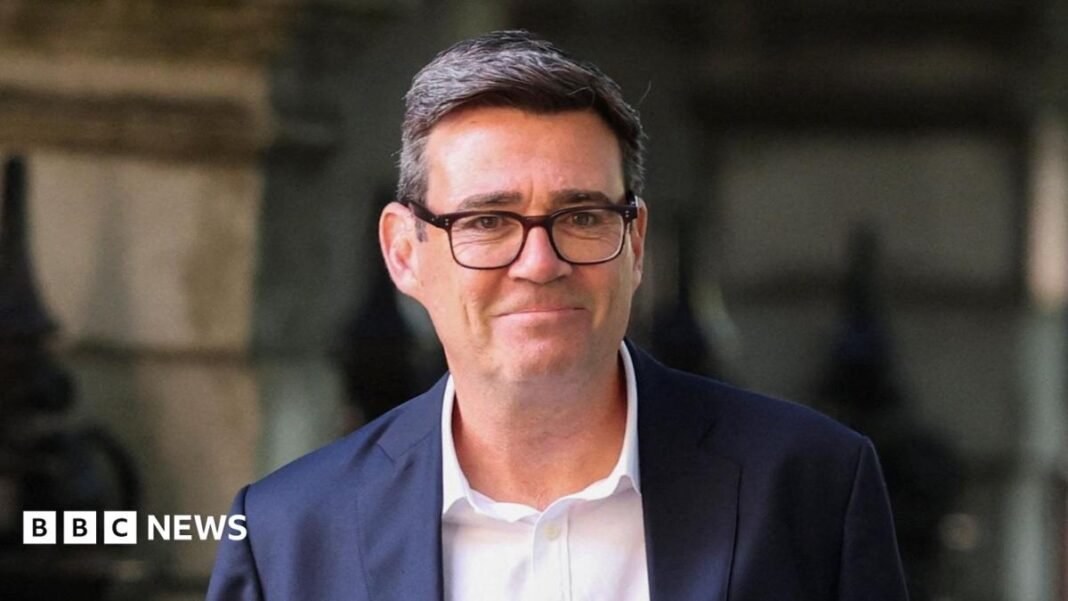 Andy Burnham wearing a dark suit and a white shirt