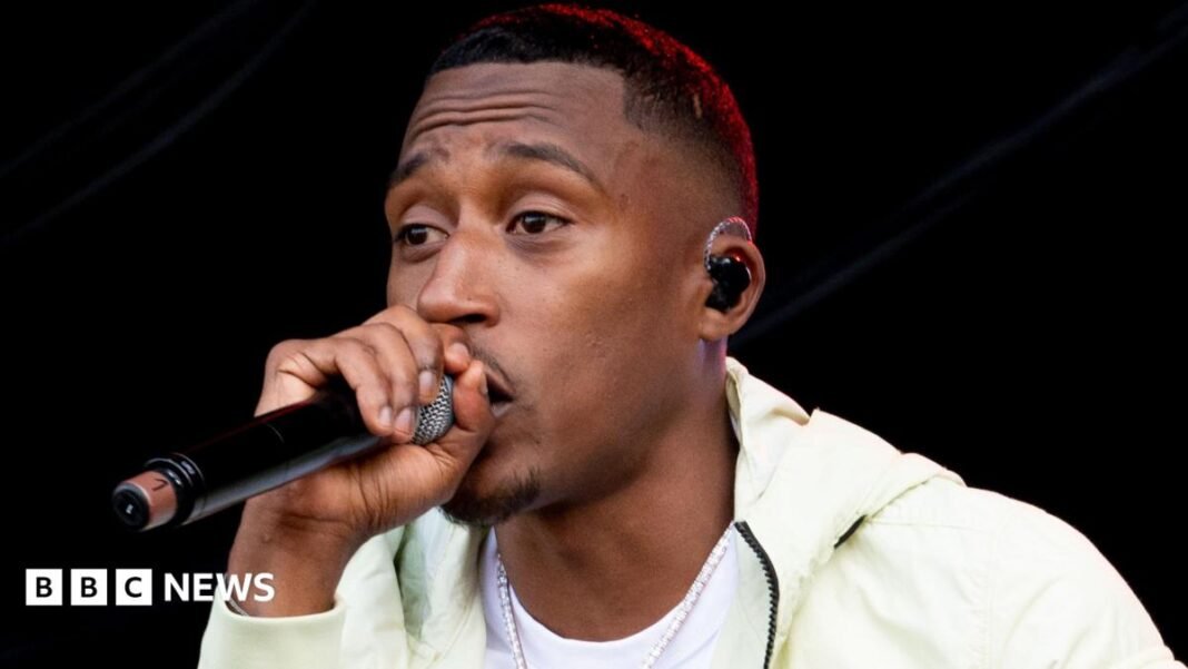 Rapper Yung Filly tells trial 'vibes were good' with woman A woman with short brown hair looks directly into the camera with a slight smiling expression. She is wearing a pink top and a silver necklace with a heart charm.