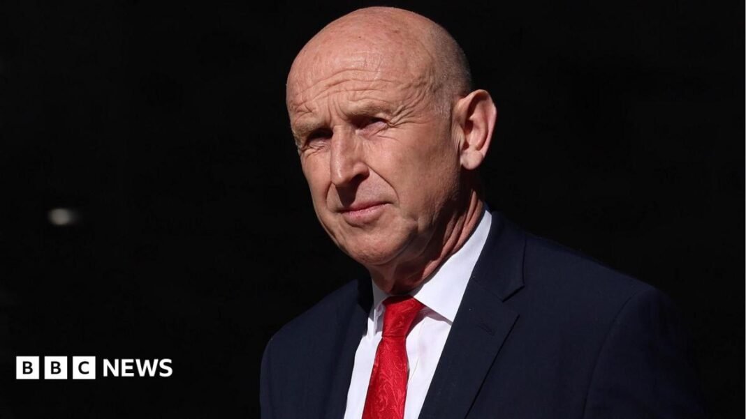 Who is new chancellor John Healey? Labour veteran who quit A head and shoulders profile shot of a bald older man in a blue suit, white shirt and deep blue business suit.