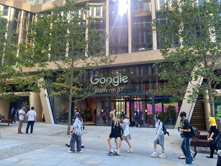 Exterior view of the Google building main entrance, platform 37 with pedestrians walking by.