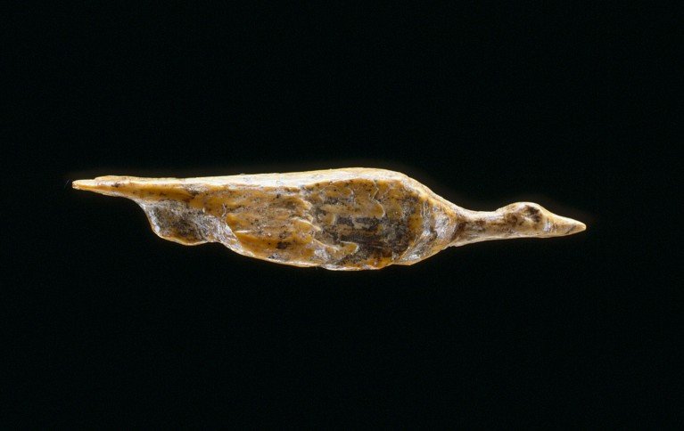 A small bird-shaped figurine photographed against a black background