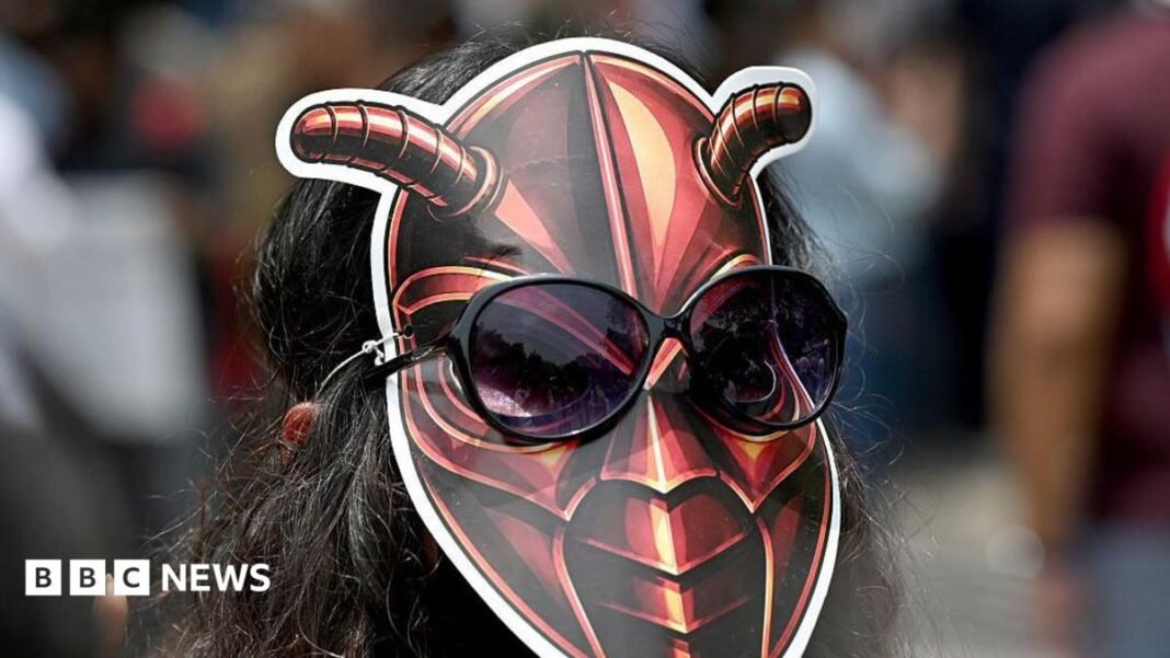 A woman wearing a cockroach mask on the back of her head