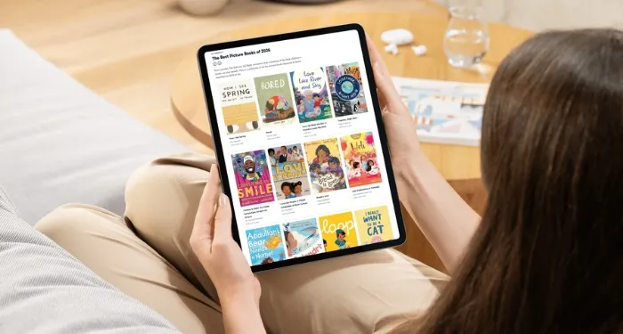 31 of the Best Picture Books of 2026 So Far someone holding a tablet displaying a collection titled The Best Picture Books of 2026