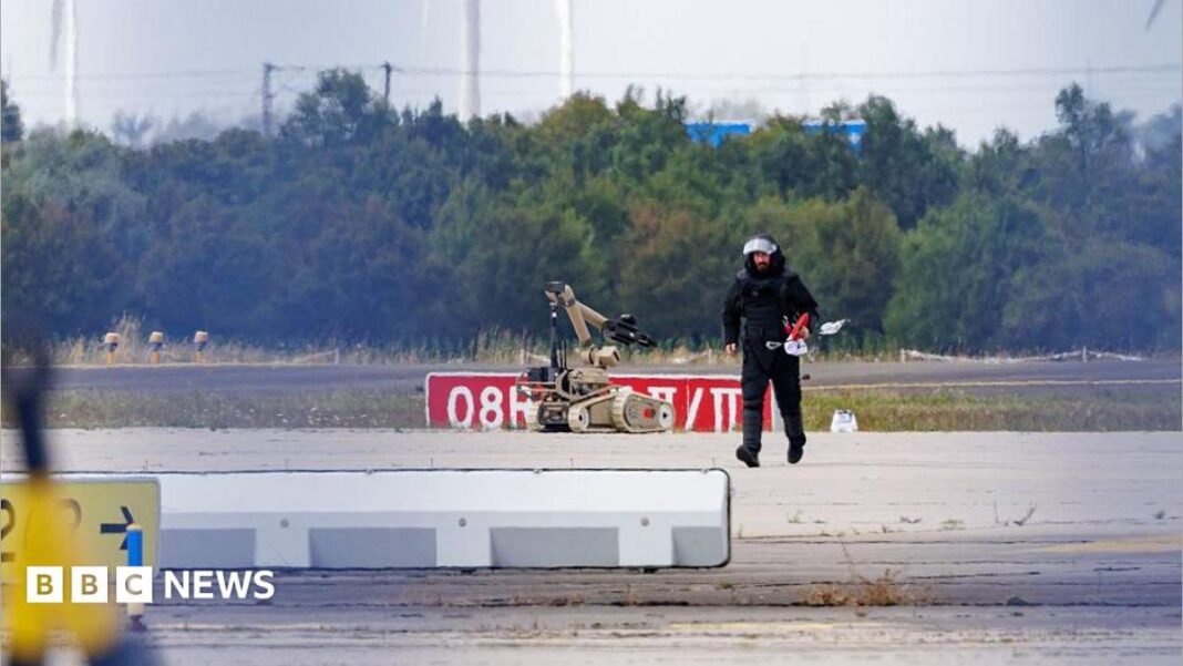 A police investigator works on the tarmac at Leipzig/Halle Airport on August 5, 2026, with a robot next to him