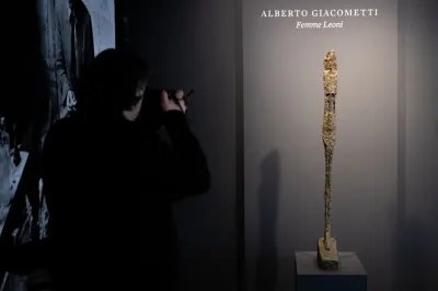 NEW YORK, NEW YORK - MAY 08: A person takes a photo of Alberto Giacometti's "Femme Leoni", (conceived in 1947 and cast in bronze by Susse Fondeur in 1960) while on display during a press preview at Sotheby's on May 08, 2023 in New York City. It is expected to be auctioned between $25-35 million during the Modern Evening Auction on May 16, 2023.  (Photo by Alexi Rosenfeld/Getty Images)