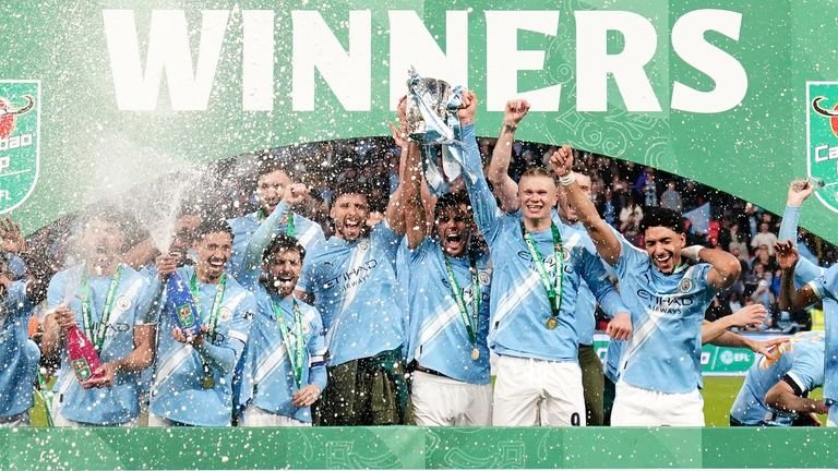 Manchester City players celebrate with the trophy after beating Arsenal 2-0 in the Carabao Cup final